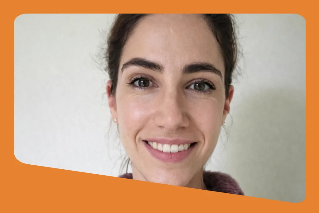 Visuel sur fond orange : gros plan d'une femme souriante aux cheveux bruns relevés, devant un mur blanc